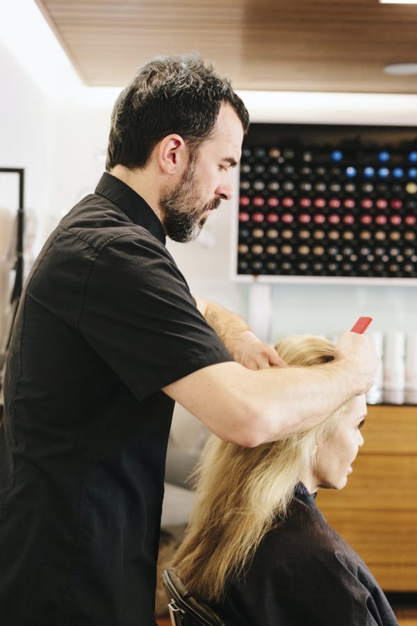 A hair stylist, colourist, working on a woman's hair